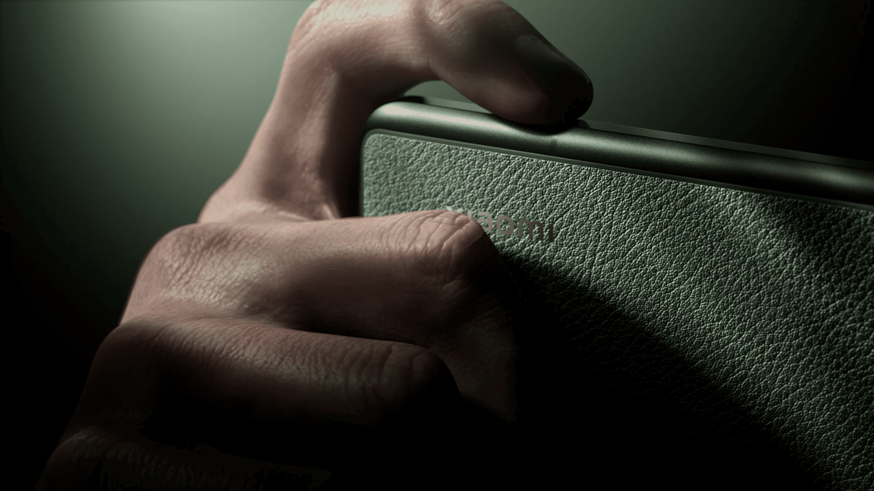 Hand gripping textured phone back — macro detail
